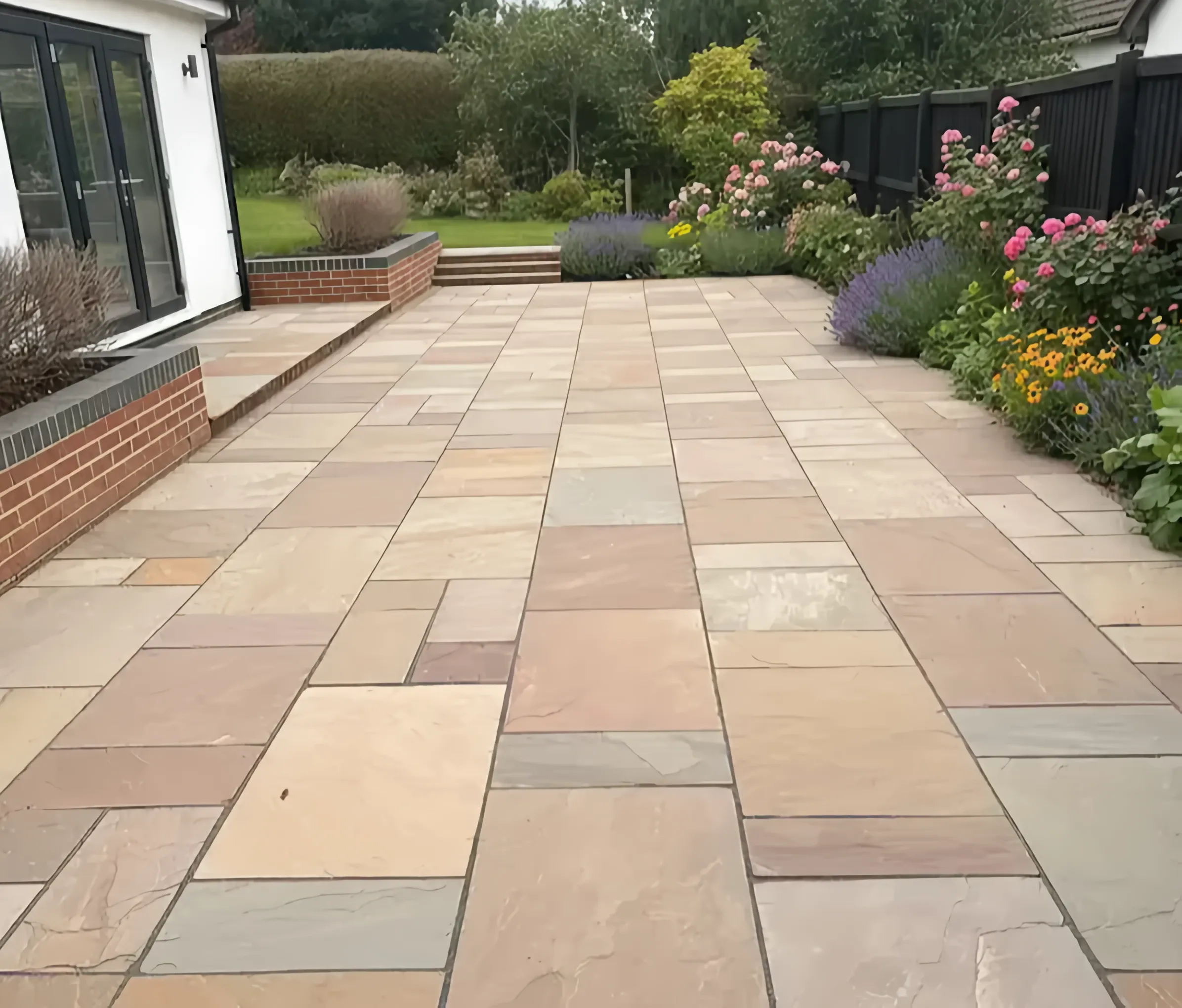 Indian sandstone patio with steps and anthracite bi-fold doors, built by Heritage in Stirling