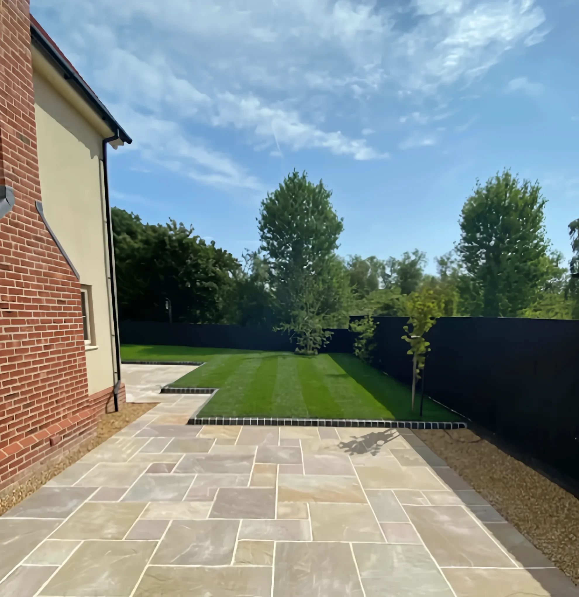 Indian sandstone patio under a blue sky in a Stirling garden