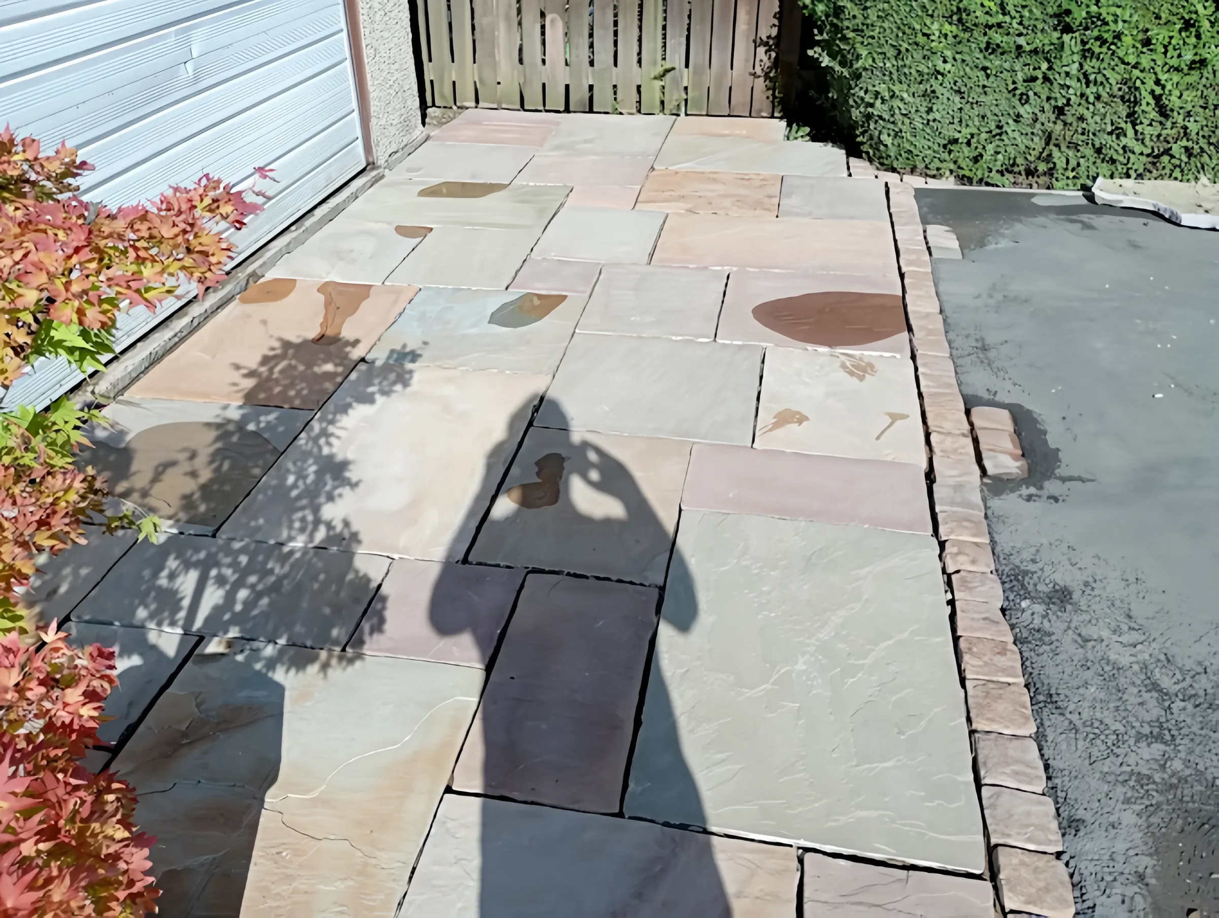 Indian sandstone paving with a charcoal sett border