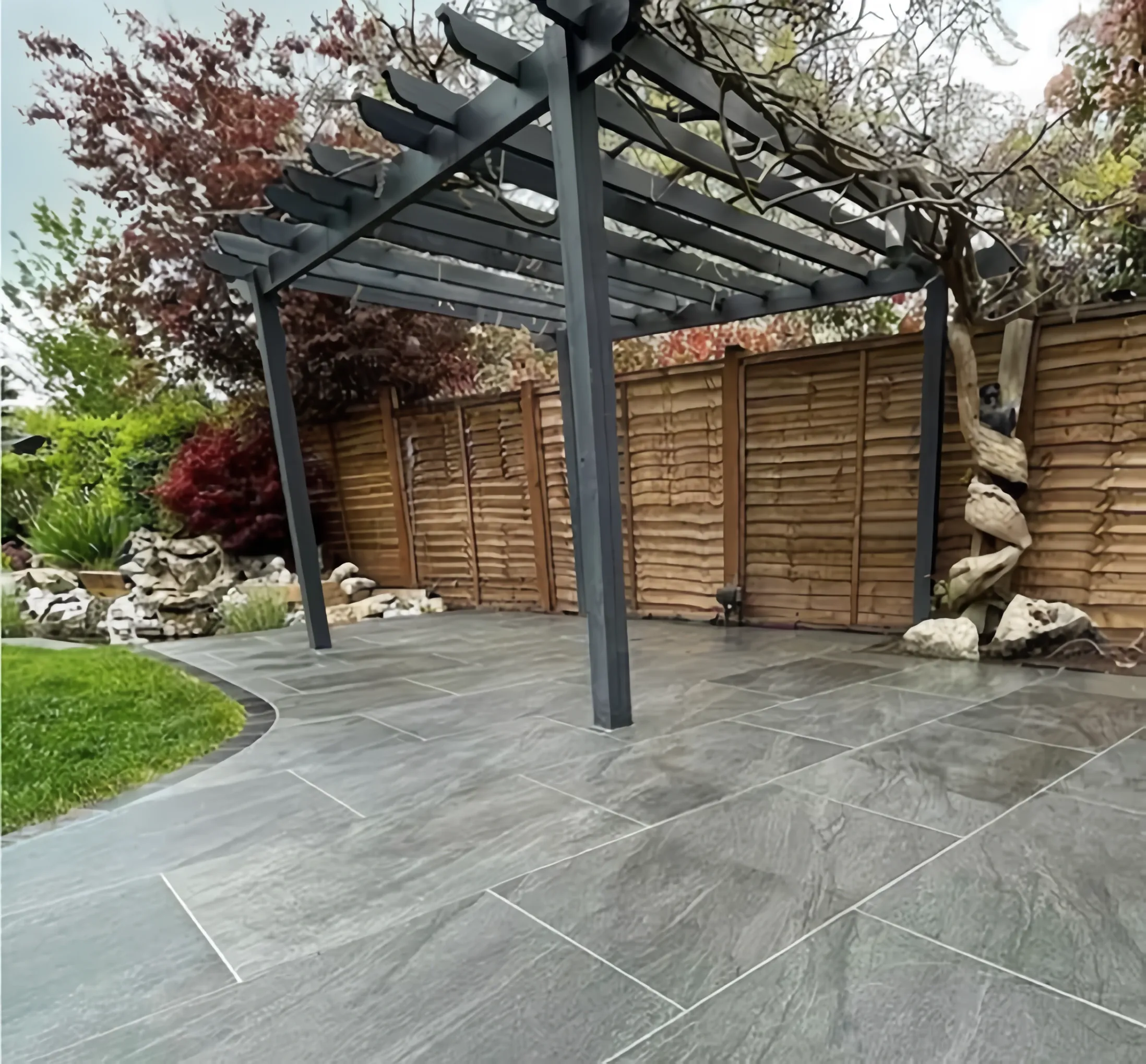 Porcelain patio beneath a timber pergola with an acer tree